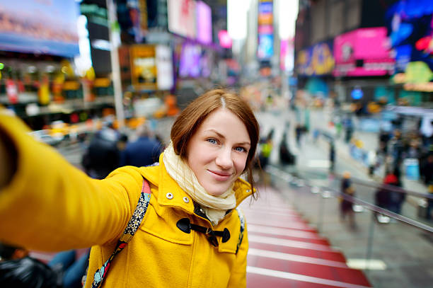 piękna kobieta biorąc sobie selfie na times square - new york city times square crowd people zdjęcia i obrazy z banku zdjęć