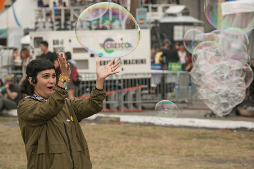 San Francisco, CA, USA - October 17th, 2015: A woman in the crowd at the 2015 Treasure Island Music festival is playing with soap bubbles. 