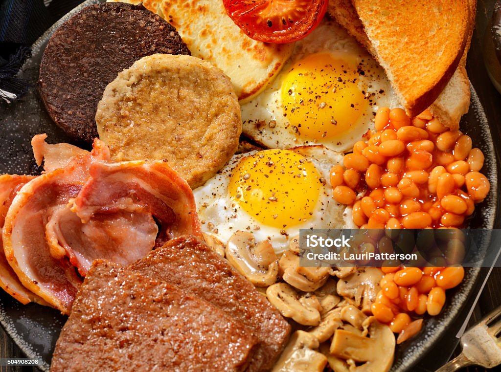 Full Traditional Scottish Breakfast Sunny side up Eggs with Haggis,Blood Pudding, Sausage, Bacon, Beans, Mushrooms, Toast and Tomatoes-Photographed on Hasselblad H3D-39mb Camera Diner Stock Photo