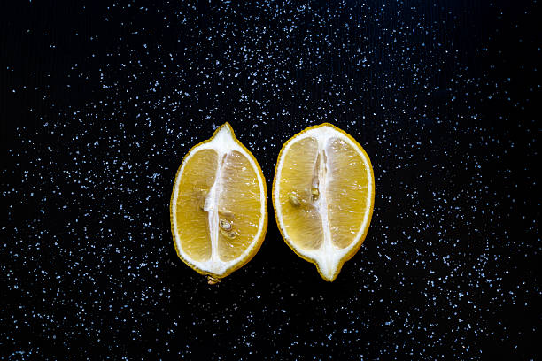 istock Two halves lemon on a black table with sugar 504908220
