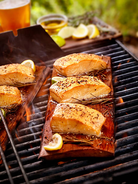 cedar plank filetti di salmone su un barbecue all'aperto - prepared fish seafood barbecue grilled foto e immagini stock