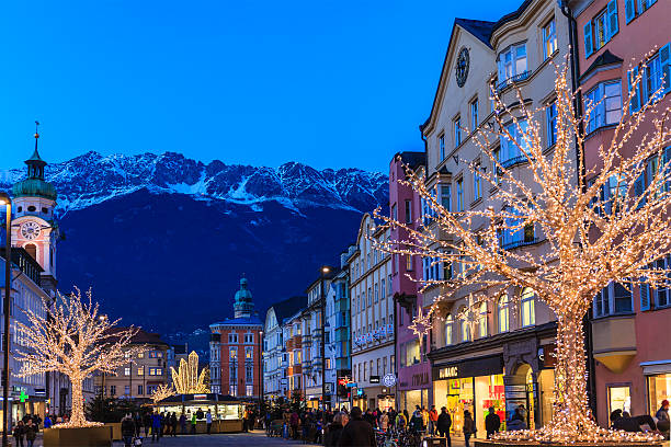 Innsbruck, Austria - December 18, 2013: People strolling in a commercial street in the old town of Innsbruck decorated for Christmas.
