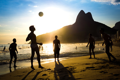 Rio de Janeiro, Brazil - December 19, 2015: Silhouette of locals playing ball at sunset in Ipanema beach, Rio de Janeiro, Brazil.