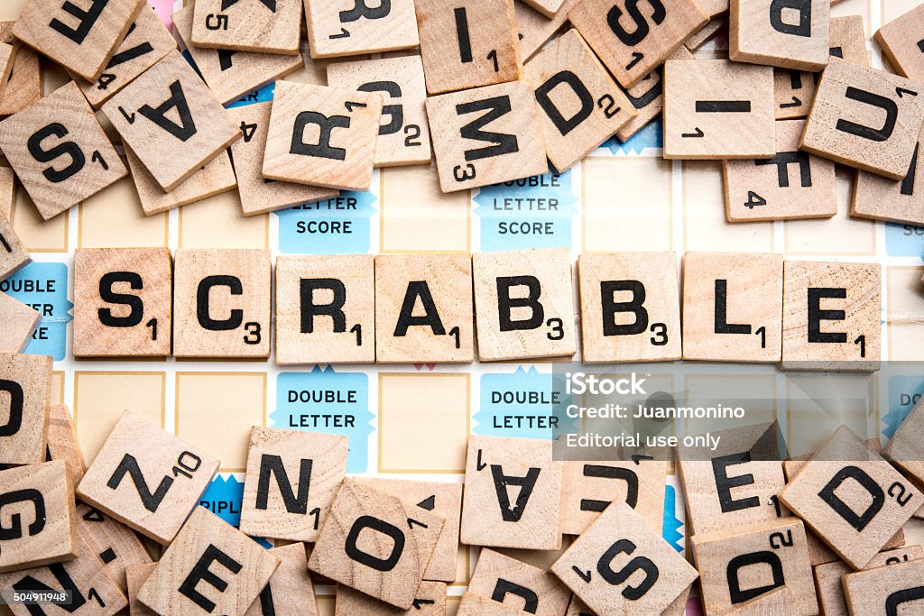 Word SCRABBLE in Scrabble Letters Miami, Florida, USA - May 25, 2015: Lettered wooden tiles mixed up on Scrabble game board, with the word SCRABBLE in the middle. Scrabble is a fun and educational game distributed by Hasbro Scrabble Stock Photo