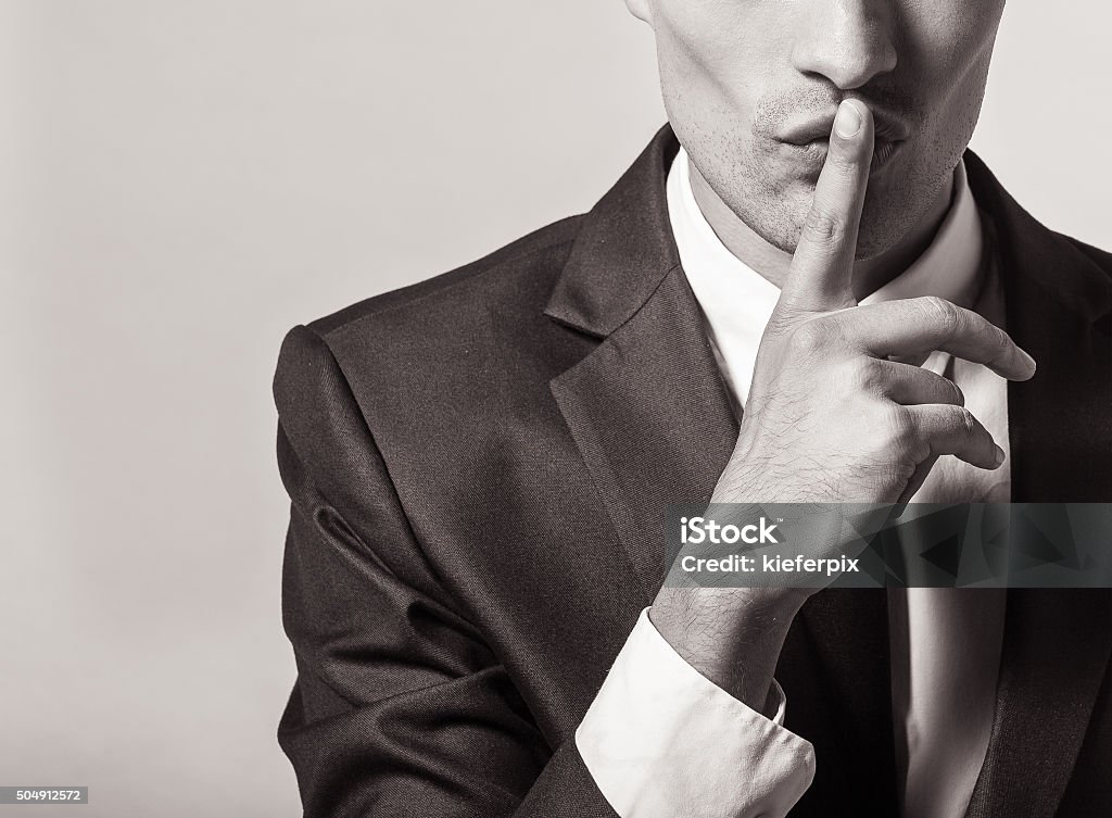 Shhh! Portrait of a young businessman with finger on his lips Finger on Lips Stock Photo