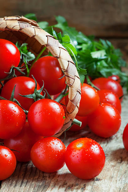 istock Small red cherry tomatoes spill out of a wicker basket 504913572