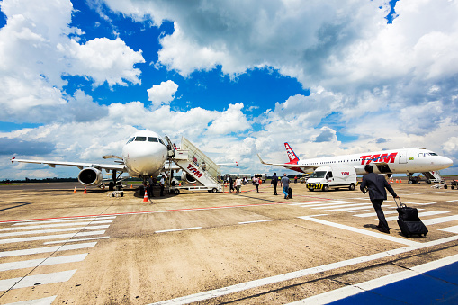 Foz do Iguacu, Brazil - December 09, 2015: Passengers boarding Tam Airlines Airbus 320 airplane at Cataratas International Airport in Foz do Iguacu, Parana, Brazil. TAM is the Brazilian brand of Latam Airlines and the largest Brazilian airline.