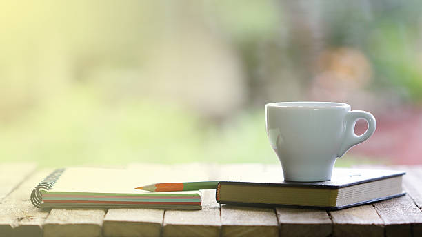 istock Notebook and mini white cup on wooden table 504922574