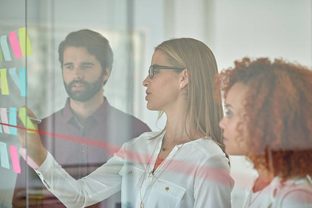 istock Using glass door to make presentation to her colleagues 504923924