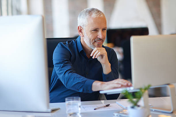 Making use of online resources Cropped shot of a mature businessman working at his deskhttp://195.154.178.81/DATA/i_collage/pi/shoots/806194.jpg mature businessman stock pictures, royalty-free photos & images