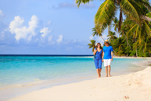 istock happy loving couple walking on beach 504929186