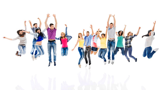 Group of happy young people having fun together while jumping with hands raised and looking at camera. Isolated on white.