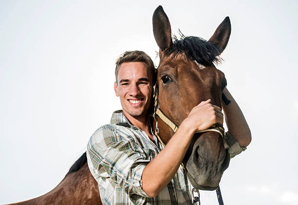 istock Happy man with horse against the sky looking at camera. 504929962
