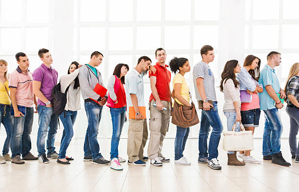 istock Group of bored students standing in a line and waiting. 504930980