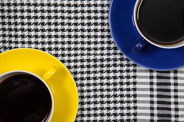 Blue and Yellow cups of coffee and Arab scarf on a table