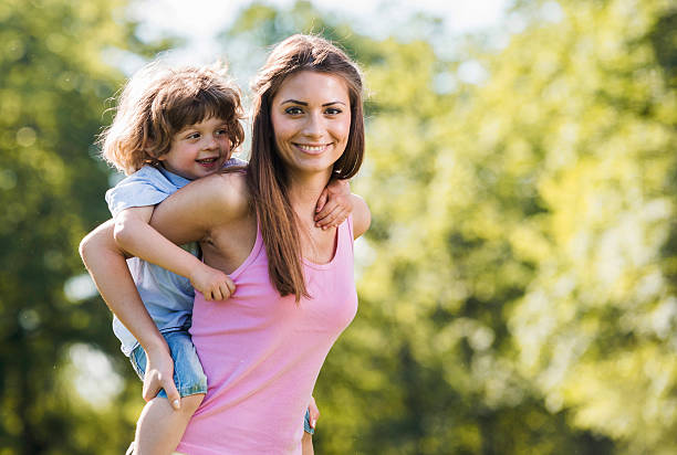 istock Smiling mother piggybacking her son in nature. 504932990