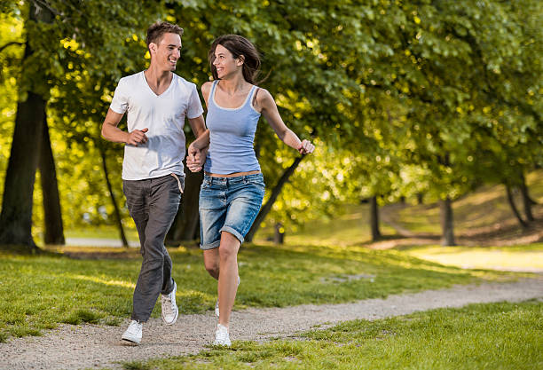 istock Smiling couple running together in the park. 504933048