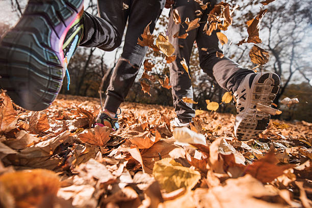 Two unrecognizable people jogging in autumn day.
