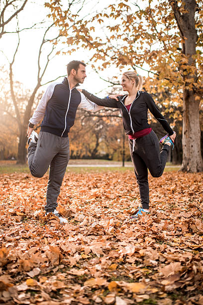 istock Young athletes cooperating while stretching during autumn day in park. 504933344