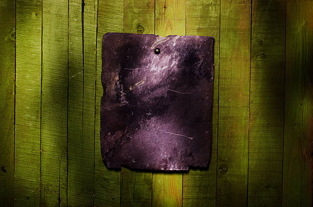 istock Black blank stone with copy space on green wooden table. 504933862