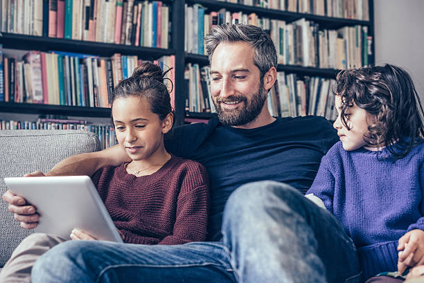 istock happy little family on sofa looking at tablet computer 504980052