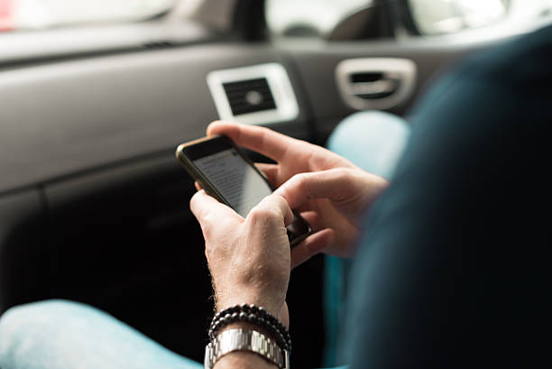 istock man tapping at  smartphone in car 504980482