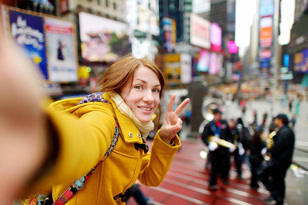 piękna kobieta biorąc sobie selfie na times square - new york city times square crowd people zdjęcia i obrazy z banku zdjęć