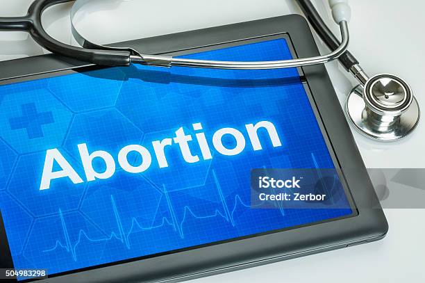 Tablet With The Text Abortion On The Display Stock Photo - Download Image Now - Abortion, Medical Clinic, Internet