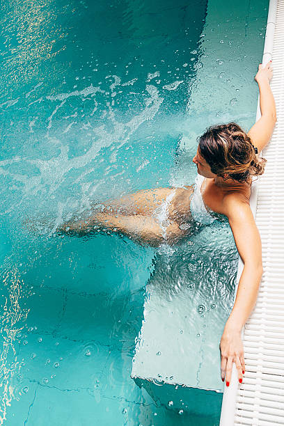 gesunde frau genießt entspannenden tag im spa-center in badeanzug - sauna und nassmassage stock-fotos und bilder