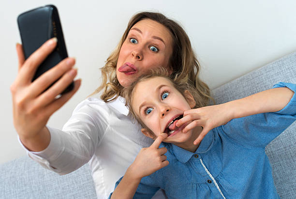 istock Mother and daughter taking selfie with mobile phone. 504984616