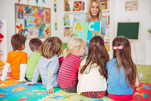 Little girl learning days of week at kindergarten. Didactic materials on the velcro board using for preschool education. Selective focus.