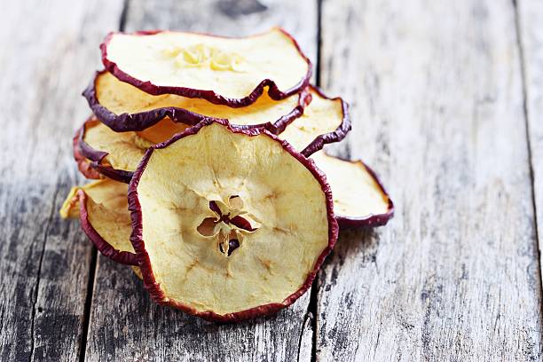 istock Sun dried apple chips on a rustic wooden table. 504988932