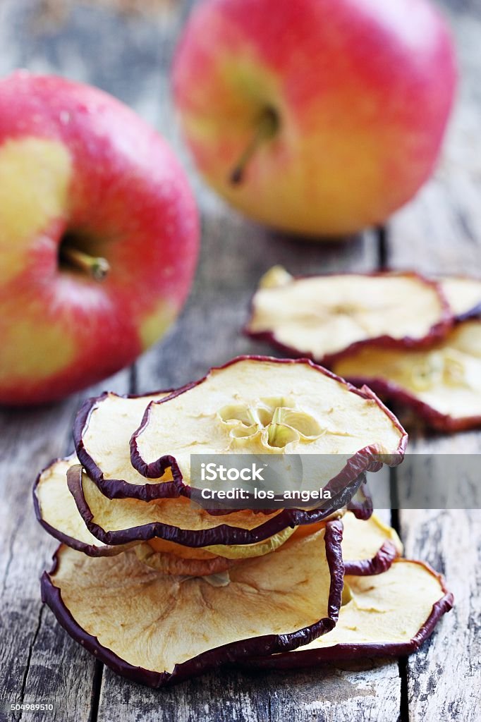 Sun dried apple chips on a rustic wooden table.Healthy snack Sun dried apple chips on a rustic wooden table.Healthy snack.Selective focus  Antioxidant Stock Photo