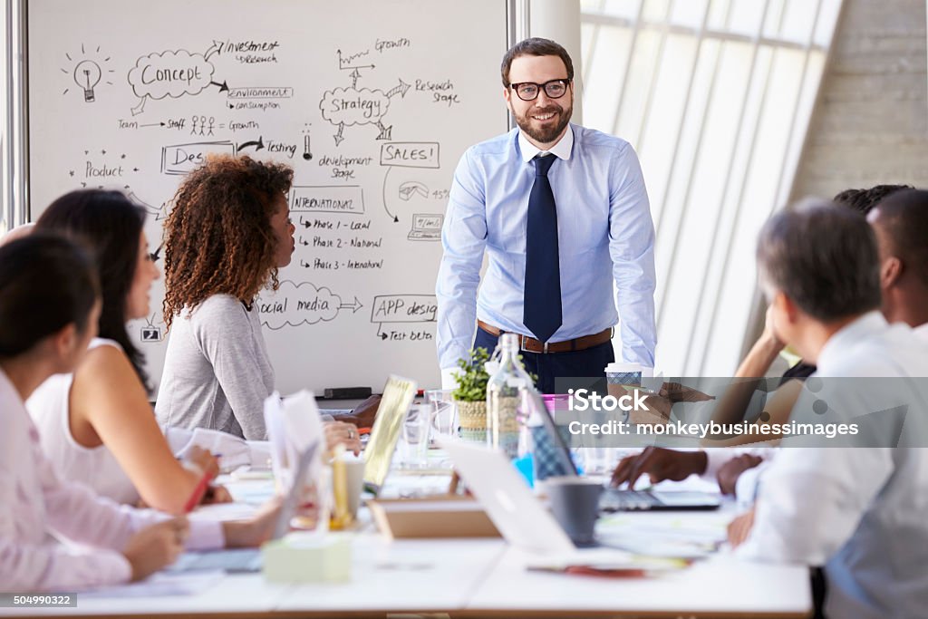 Caucasian Businessman Leading Meeting At Boardroom Table Business Stock Photo