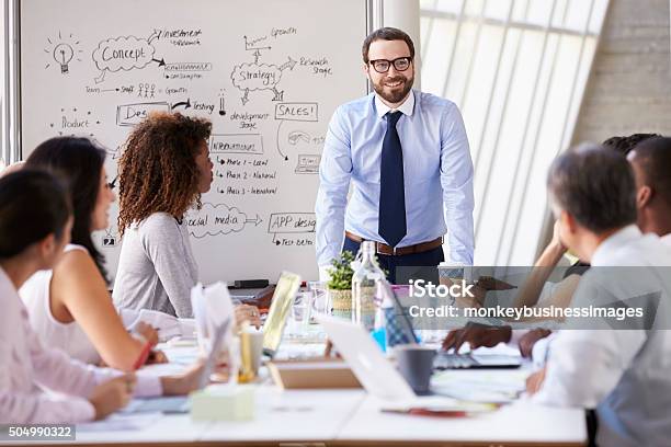 Caucasian Businessman Leading Meeting At Boardroom Table Stock Photo - Download Image Now