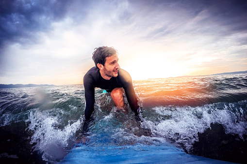 Portrait of a determined surfer who enjoys perfect wave on the ocean