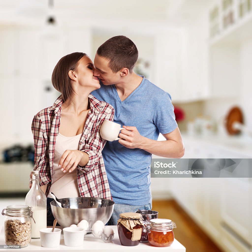 happy young couple have fun in modern wooden kitchen happy young couple have fun in modern wooden kitchen indoor while preparing fresh food Adult Stock Photo