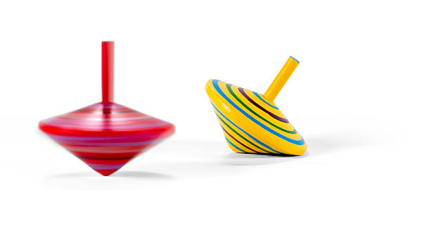 Two wooden and colorful spinning tops Two wooden and colorful spinning tops: the red one is turning, the yellow one stopped. spinning top stock pictures, royalty-free photos & images