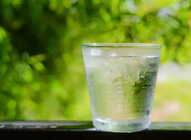 Glass water,Ice glass on green blur background.focus glass top.