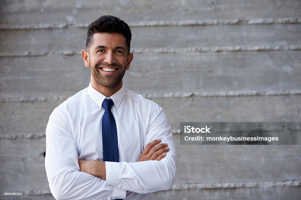 Hispanische Geschäftsmann stehend gegen Wand In modernen Büro - Lizenzfrei Lateinamerikanische Abstammung Stock-Foto