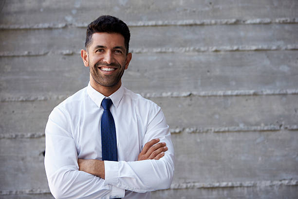 hispanic homme d'affaires debout contre le mur de bureau moderne - shirt necktie men businessman photos et images de collection