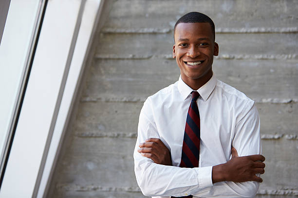 afro-américaine homme d'affaires debout contre le mur - shirt necktie men businessman photos et images de collection