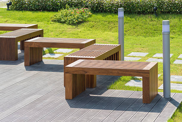 Wood bench in garden with small green tree in background