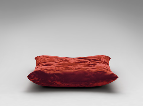 Red velvet pillow on gray background with clipping path. 3D render