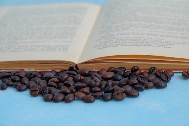 a cup of dark coffee with an old book wood ground