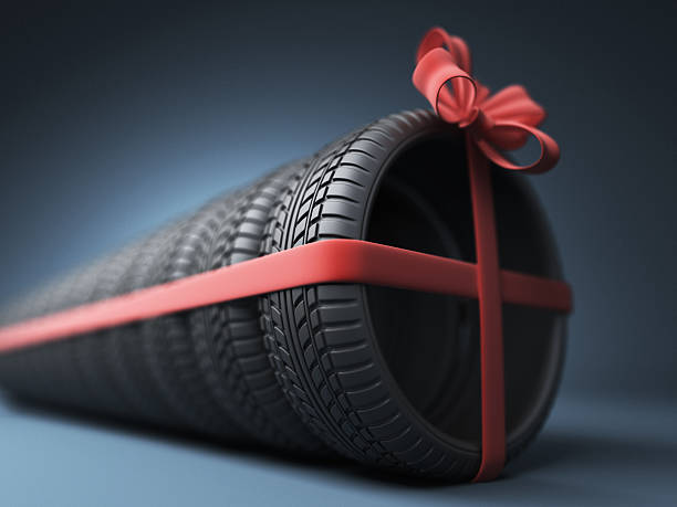 Tire with a red ribbon. Gift. 3D stock photo