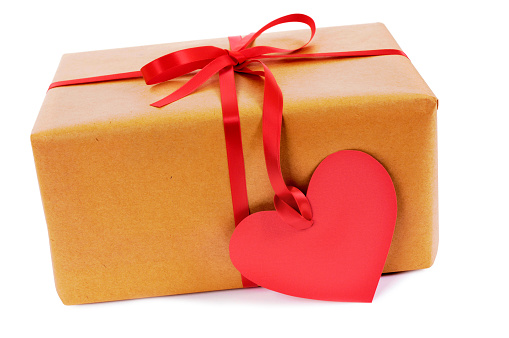 Valentine gift, brown paper parcel with red heart shape gift tag isolated on white background.