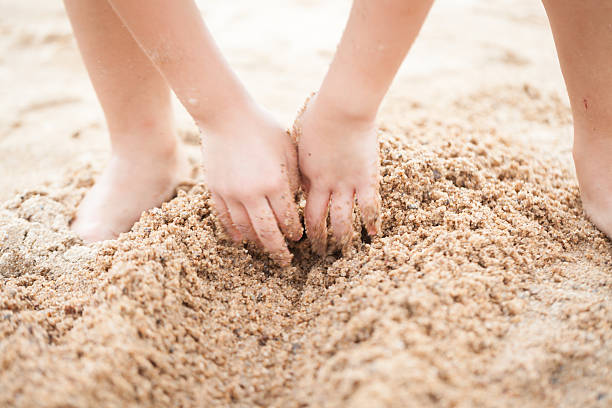 Kid digging holes in the sand cowork