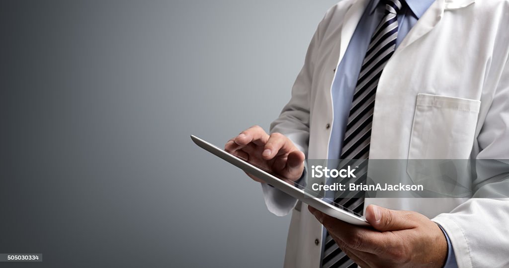 Doctor usando tableta digital - Foto de stock de Doctor libre de derechos