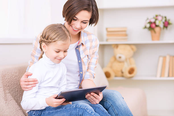 istock Little girl and her mom are using tablet 505031736